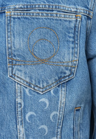 Τζιν μπουφάν σε ανοιχτό μπλε με ξεθωριασμένη υφή, διακοσμημένο με κεντημένο πορτοκαλί κύκλο στην πίσω τσέπη και διακριτικά μοτίβα σε σχήμα ημισελήνου.