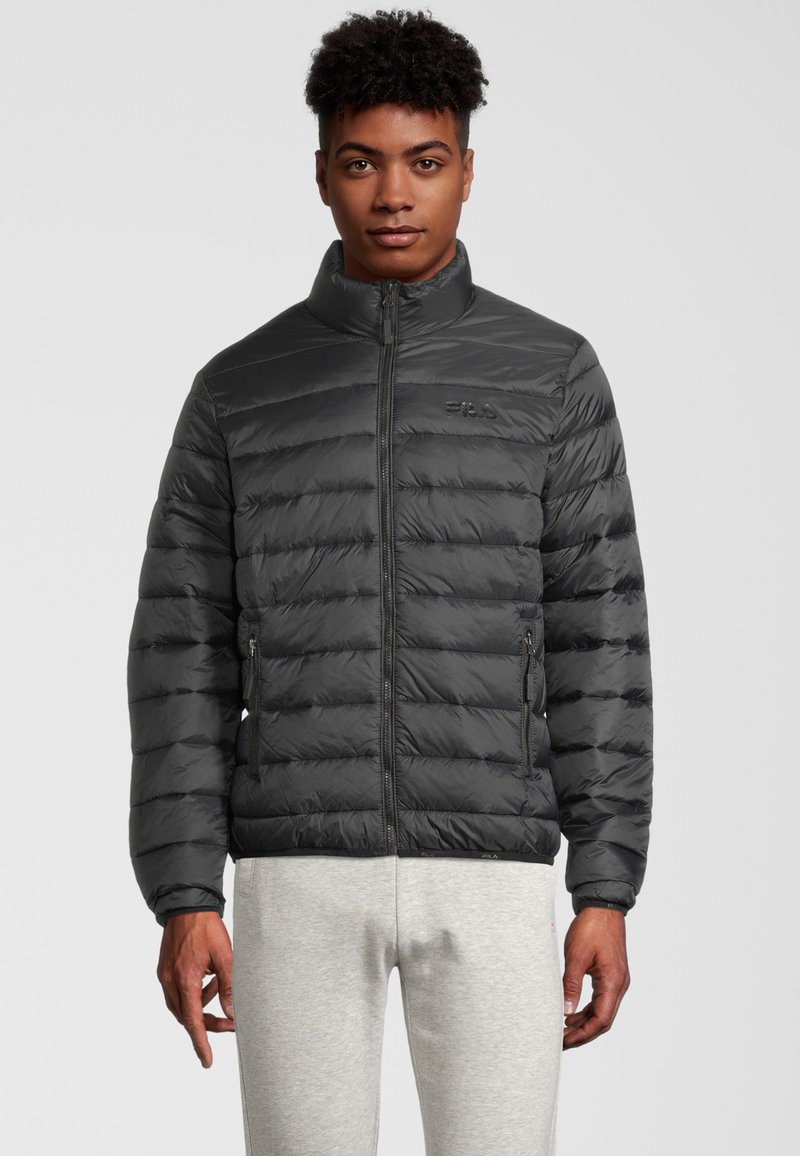 Svart puffjacka med kviltat mönster, hög krage, zip-up framknäppning och sidofickor. Slät textur med subtila logodetaljer.