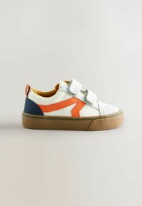 Witte en oranje canvas sneaker met klittenband, blauwe accenten en een bruine gestructureerde zool, met een minimalistisch ontwerp.