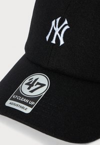 Sort justerbar baseballkasket med hvid broderet NY-logo og et '47 Clean Up mærkestik på skyggen.