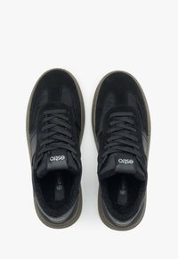 Czarne sneakersy wykonane z zamszu i materiałów syntetycznych; posiadają teksturowane akcenty, zapięcie na sznurowadła oraz gumową podeszwę z teksturowanym brzegiem.