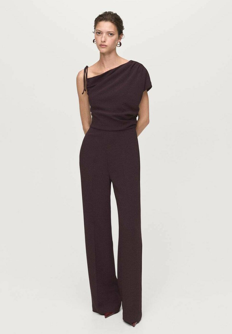 Bordeaux een-schouder jumpsuit met wijde pijpen, rekbaar stof en een trekkoordaccent op de schouder. Gladde textuur; minimalistisch ontwerp.