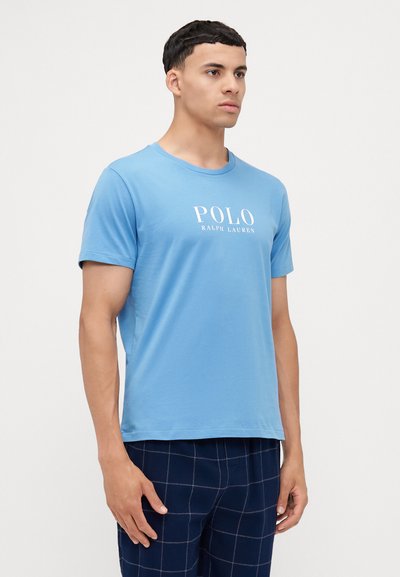 Modrá bavlnená tričko s okrúhlym výstrihom, krátkymi rukávmi a bielym potlačeným logom "POLO RALPH LAUREN" na prednej strane.