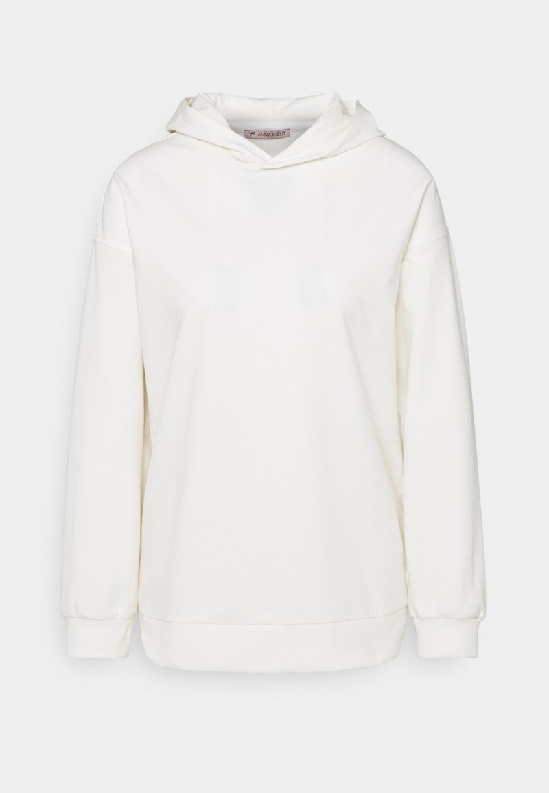 Sudadera blanca con capucha hecha de tela suave. Mangas anchas y corte relajado con ribete en el dobladillo. Etiqueta visible en el interior del escote.