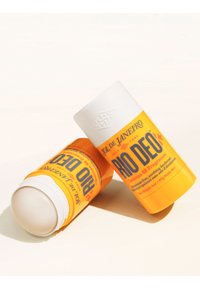 Due stick deodoranti Sol de Janeiro Rio Deo giallo e bianco senza alluminio su sfondo chiaro. Uno stick è aperto, mostrando la superficie del prodotto.