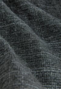 Tejido gris oscuro con un sutil patrón texturizado, exhibiendo suaves pliegues y un ligero brillo, fabricado a partir de un material textil.
