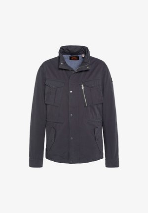 Chaqueta azul marino oscura de tejido suave, con cuello alto, múltiples bolsillos, cierre frontal de cremallera y botones.