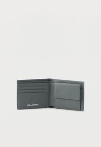 Szary skórzany portfel składany z slotami na karty po lewej stronie i kieszenią na monety z klapką po prawej stronie, z logo KARL LAGERFELD.