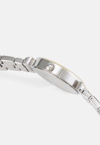 Orologio in acciaio inox argentato con cassa rotonda, design minimalista, corona texturizzata e bracciale a maglie.