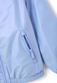 Helle blaue Jacke aus glänzendem Material, mit einer Reißverschlusstasche am Ärmel und elastischen Bündchen am Saum für eine enge Passform.