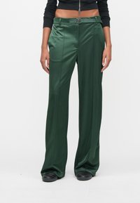 Πράσινο, σατινέ παντελόνι με ευθεία γραμμή, διαθέτει ζώνη με μεταλλική αγκράφα και πιέτες μπροστά. Λείο υφή, εφαρμοστή μέση.
