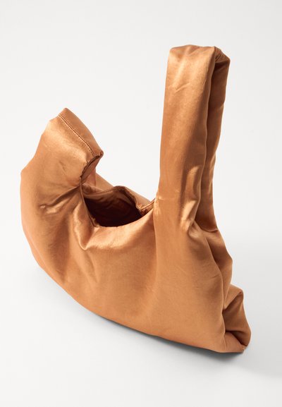 Sac à main en bronze satin avec une ouverture ronde, texture douce et une seule poignée, présentant un design décontracté et des coutures minimalistes.