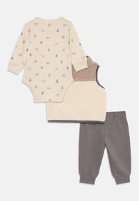 Beige lange mouwen baby rompertje met dieren- en boomprints, crèmekleurig en bruin pluizig vest, en grijze broek met elastische tailleband.
