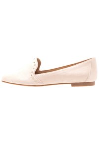 Chaussure plate en suède rose clair avec un petit talon, un bout arrondi et des accros décoratifs le long du bord extérieur. Design simple avec une texture douce.