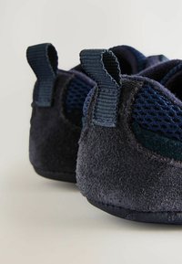 Mörkblå klättertskor i mocka och mesh-material; har hälöglor och strukturerade sulor för grepp.