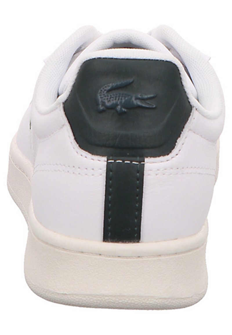 Białe sneakersy z teksturowaną skórzaną cholewką, ciemnozielonym uchwytem na pięcie i wytłoczonym logo krokodyla. Posiadają amortyzowaną podeszwę oraz minimalistyczny design.