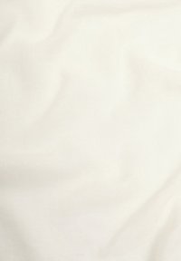 Tissu ivoire clair avec une texture douce et lisse, présentant de légers plis et un léger éclat ; sans motifs ni ornements visibles.