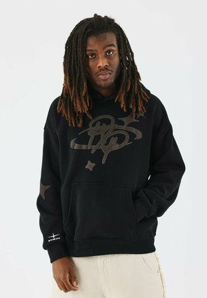 Sudadera negra con un gran logo reflectante y diseños de estrellas. Cuenta con un bolsillo frontal, capucha ajustable y puños acanalados. Textura de tela suave.
