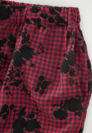 Red and black checkered fabric featuring black floral patterns, with gathered elastic waistband and smooth texture.