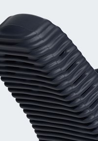 Dark blue chair made of cushioned layers in a ribbed design. Features evenly spaced slots and a smooth, textured finish.