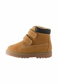 Braune Wildleder-Ankle-Boots mit zwei Klettverschlüssen, einem gefütterten schwarzen Kragen und einer Gummisohle mit strukturiertem Profil für besseren Halt.