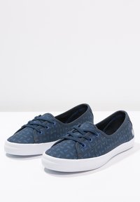 Marina canvas sneakers med en strukturerad mönster, med blå snörningar, vita gummisålar och rundad tådesign.