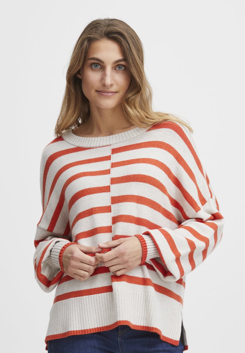 Sweter w paski w kolorze kremowym i pomarańczowym, o luźnym kroju, szerokim dekolcie w łódkę, prążkowanych mankietach i dolnym wykończeniu, z bocznymi rozcięciami dla większego komfortu.