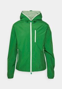 Giacca leggera verde con cappuccio, chiusura anteriore con zip e due tasche con zip. Presenta una texture liscia e dettagli con zip a contrasto.