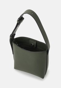 Groene leren emmerzak met een brede schouderband, voorzien van een magneetsluiting en een binnenzak. Gladde textuur met een minimalistisch ontwerp.