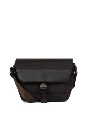 Czarna torebka na ramię z klapką, metalową klamrą i regulowanym brązowym paskiem, minimalistyczny design na białym tle.