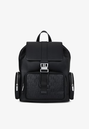 Czarna skórzana plecak z teksturowaną przednią kieszenią, srebrnym okuciem, regulowanymi szelkami i uchwytem na górze. Posiada dwie boczne kieszenie na zamek.
