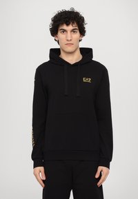 Black hooded sweatshirt made of soft fabric, featuring a kangaroo pocket, drawstrings, and gold EA7 logo on the chest and sleeve.