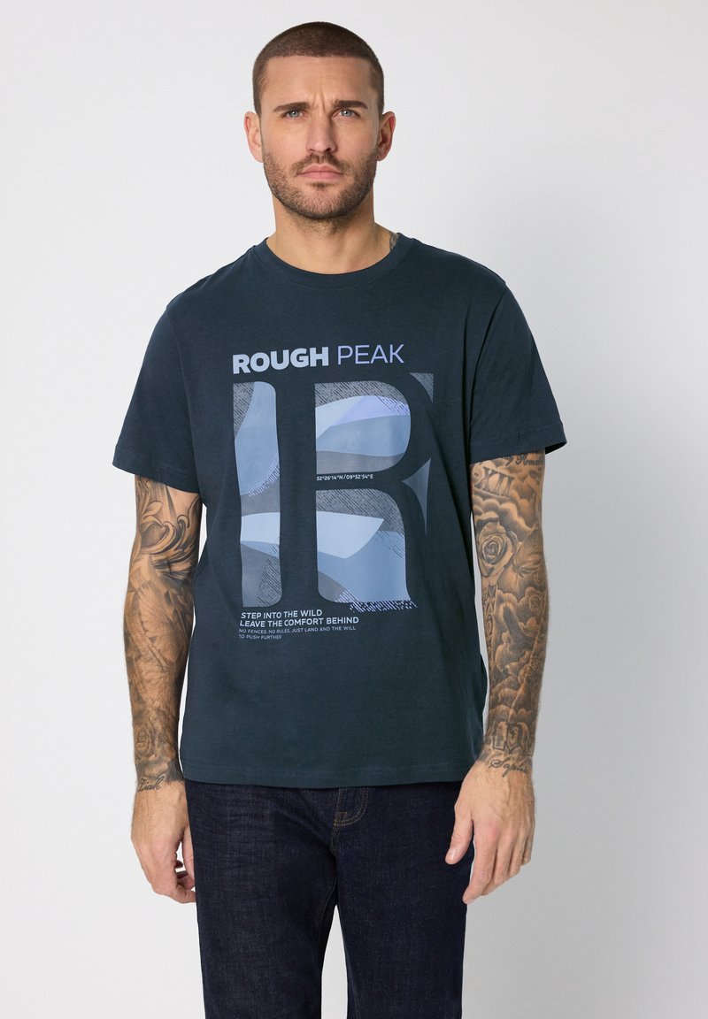 Marinblå bomulls-t-shirt med ett grafiskt tryck som visar "ROUGH PEAK" och abstrakta former. Korta ärmar och rund halsringning.