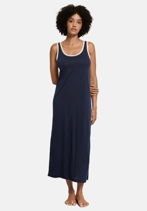 Marineblauwe lange jerseyjurk met een ronde halslijn en crèmekleurige afwerking. Heeft een losse pasvorm en zijsplitten voor meer bewegingsvrijheid.