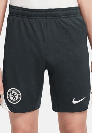 Schwarze Sportshorts mit dem Wappen des Chelsea Football Club am linken Bein und weißem Nike-Logo am rechten Bein, getragen von einer Person.