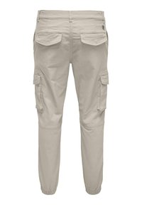 Pantalones cargo beige con múltiples bolsillos laterales, puños elásticos y una suave tela de mezcla de algodón. Textura lisa con un diseño de corte relajado.