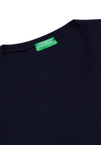 Svetle modré bavlněné svetr s kulatým výstřihem a žebrovanými detaily. Na límci se nachází zelená nálepka s nápisem "United Color of Benetton".