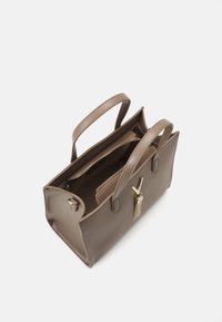 Brūna teksturēta rokassoma ar divām rokturiem, zelta detaļām un ar rāvējslēdzēju slēgtu iekšējo kabatu. Atvērta no augšas, parādot tās plašo dizainu.