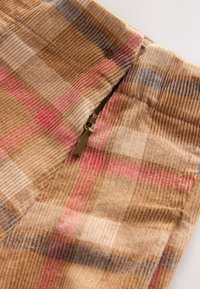 Plaid fabric in brown with accents of red and blue. Features a metal zipper at the opening, with a textured finish.