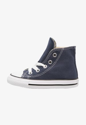 Granatowy sneaker z wysoką cholewką wykonany z płótna, z białą gumową podeszwą i nakładką na nosku. Posiada białe sznurówki i metalowe oczka, kontrastujące przeszycia oraz wyściełany kołnierz.