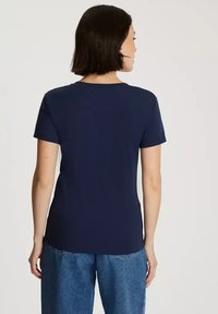 Granatowa bawełniana koszulka z okrągłym dekoltem i krótkim rękawem, o prostym kroju, bez widocznych wzorów ani akcentów.