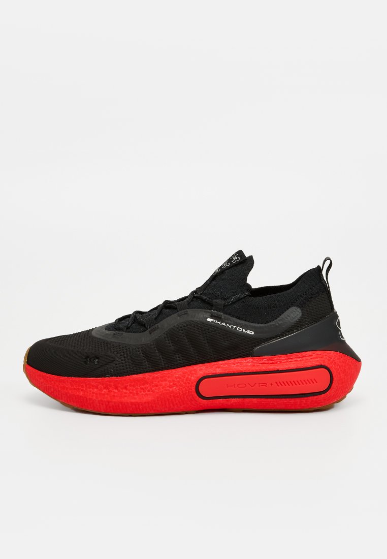 Scarpa sportiva nera con tomaia in tessuto testurizzato, intersuola rossa e suola in gomma. Presenta un accento laterale riportato e una linguetta per il pull.