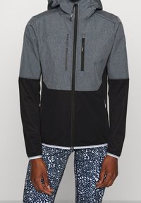 Veste zippée grise et noire avec capuche, présentant une texture lisse, deux poches zippées à l'avant et des manches contrastées.