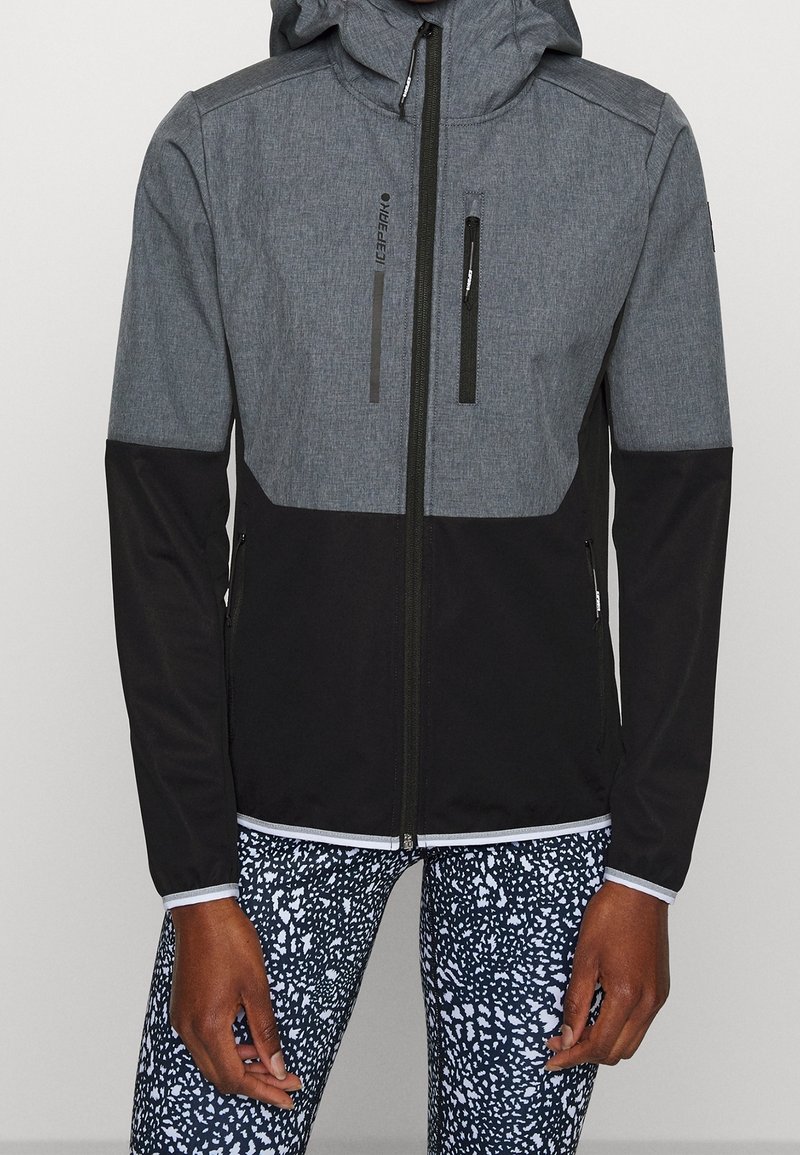 Veste zippée grise et noire avec capuche, présentant une texture lisse, deux poches zippées à l'avant et des manches contrastées.