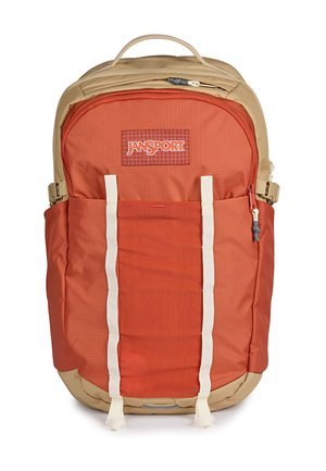 Zweifarbiger beiger und verbrannt orangefarbener Jansport-Rucksack mit mehreren Fächern, Frontgurten und Seitentaschen auf weißem Hintergrund.