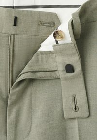 Light gray trousers with zipper, button, hook-and-bar closure, and inner waistband detail on a white surface.