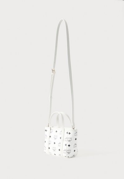 Λευκή τσάντα crossbody με μαύρα λογότυπα MCM και διαμάντι μοτίβα, με δύο κοντές λαβές και ένα μακρύ ρυθμιζόμενο λουρί.
