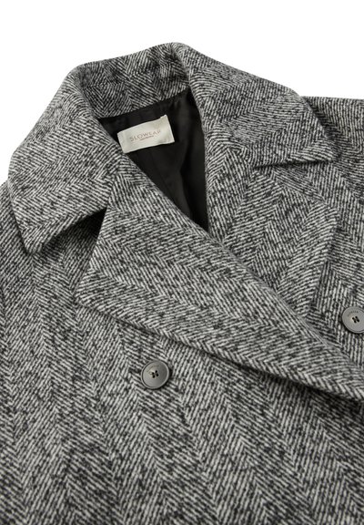 Cappotto doppiopetto in un motivo houndstooth grigio e nero, realizzato in tessuto misto lana. Presenta ampi rever a punta e dettagli con bottoni.