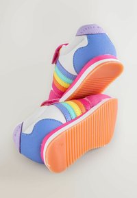 Värvikad tossud roosas, sinises ja valges värvitoonis, millel on vikerkaareriba mustriga detailid, takjakinnitused ja tekstureeritud oranž kummist tallad.