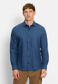 Dunkelblaues Herrenhemd mit langen Ärmeln zum Knöpfen, aus leichtem Stoff, mit einer Brusttasche und schwarzen Knöpfen. Durchgehend glatte Textur.